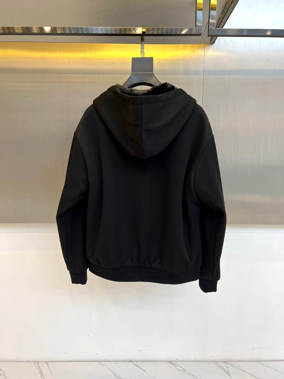 Prad普拉、2025秋冬新品连帽毛绒保暖外套，以极简主义诠释实用美学。这款外套采用立体剪裁的连帽设计，