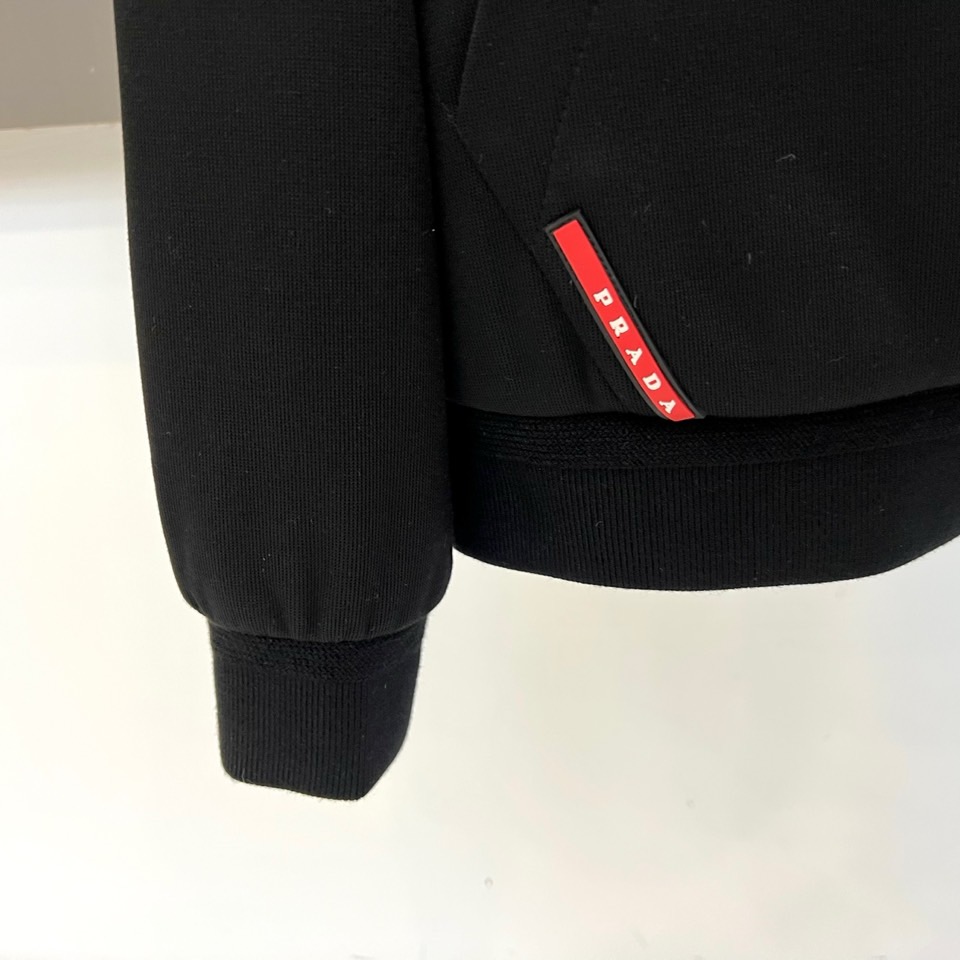 Prad普拉、2025秋冬新品连帽毛绒保暖外套，以极简主义诠释实用美学。这款外套采用立体剪裁的连帽设计，