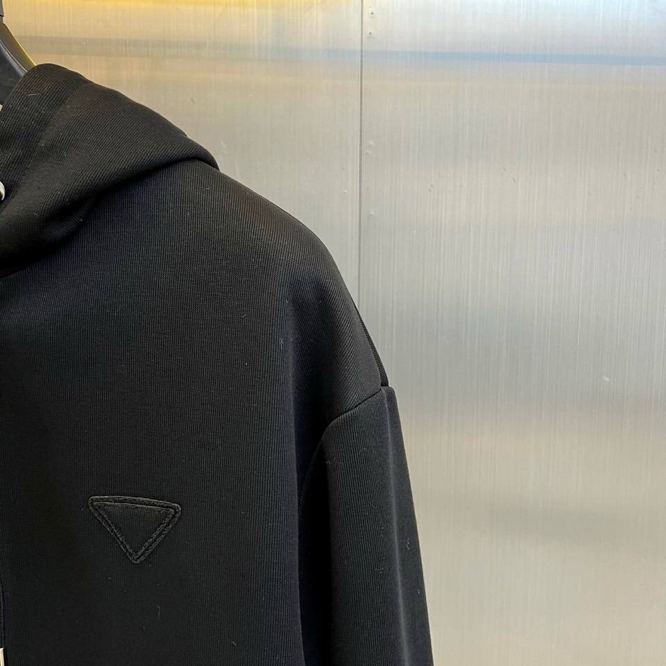 Prad普拉、2025秋冬新品连帽毛绒保暖外套，以极简主义诠释实用美学。这款外套采用立体剪裁的连帽设计，