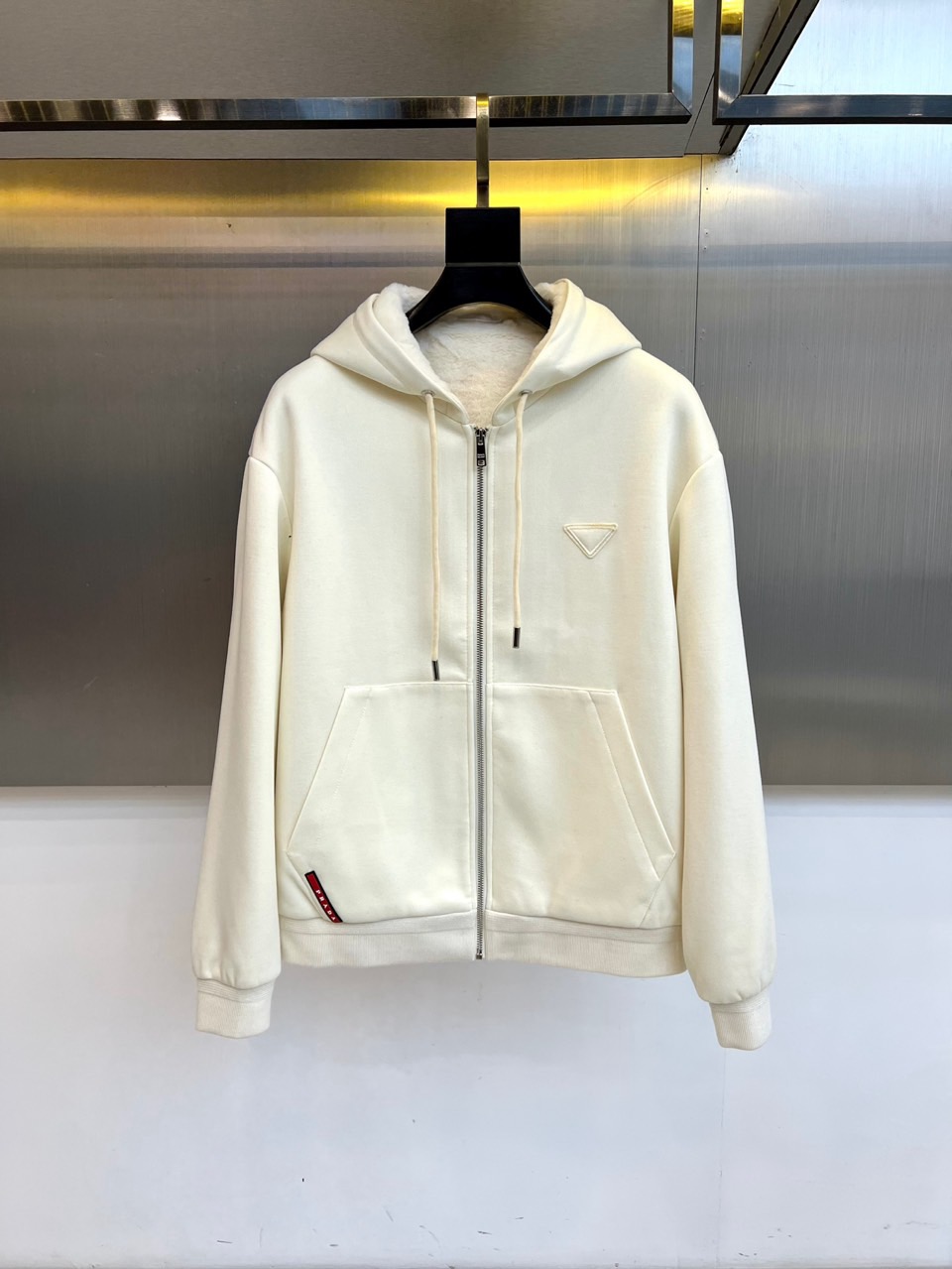 Prad普拉、2025秋冬新品连帽毛绒保暖外套，以极简主义诠释实用美学。这款外套采用立体剪裁的连帽设计，