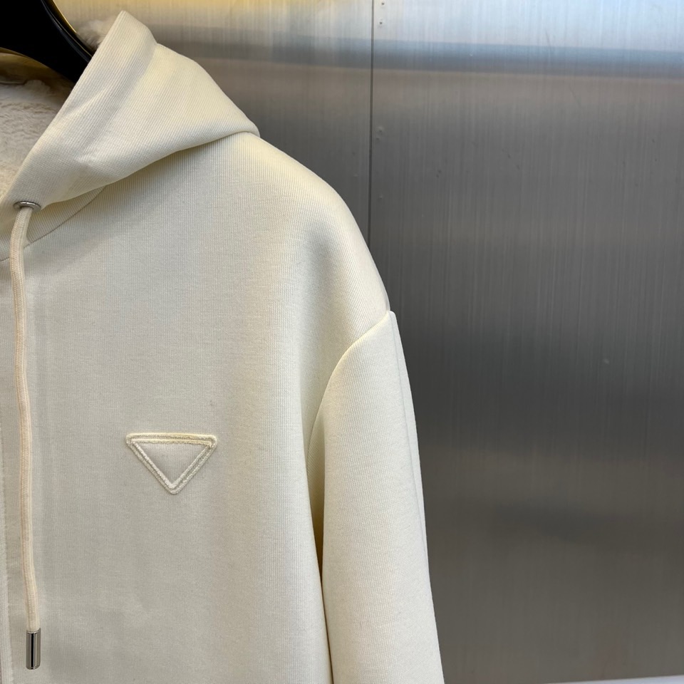 Prad普拉、2025秋冬新品连帽毛绒保暖外套，以极简主义诠释实用美学。这款外套采用立体剪裁的连帽设计，