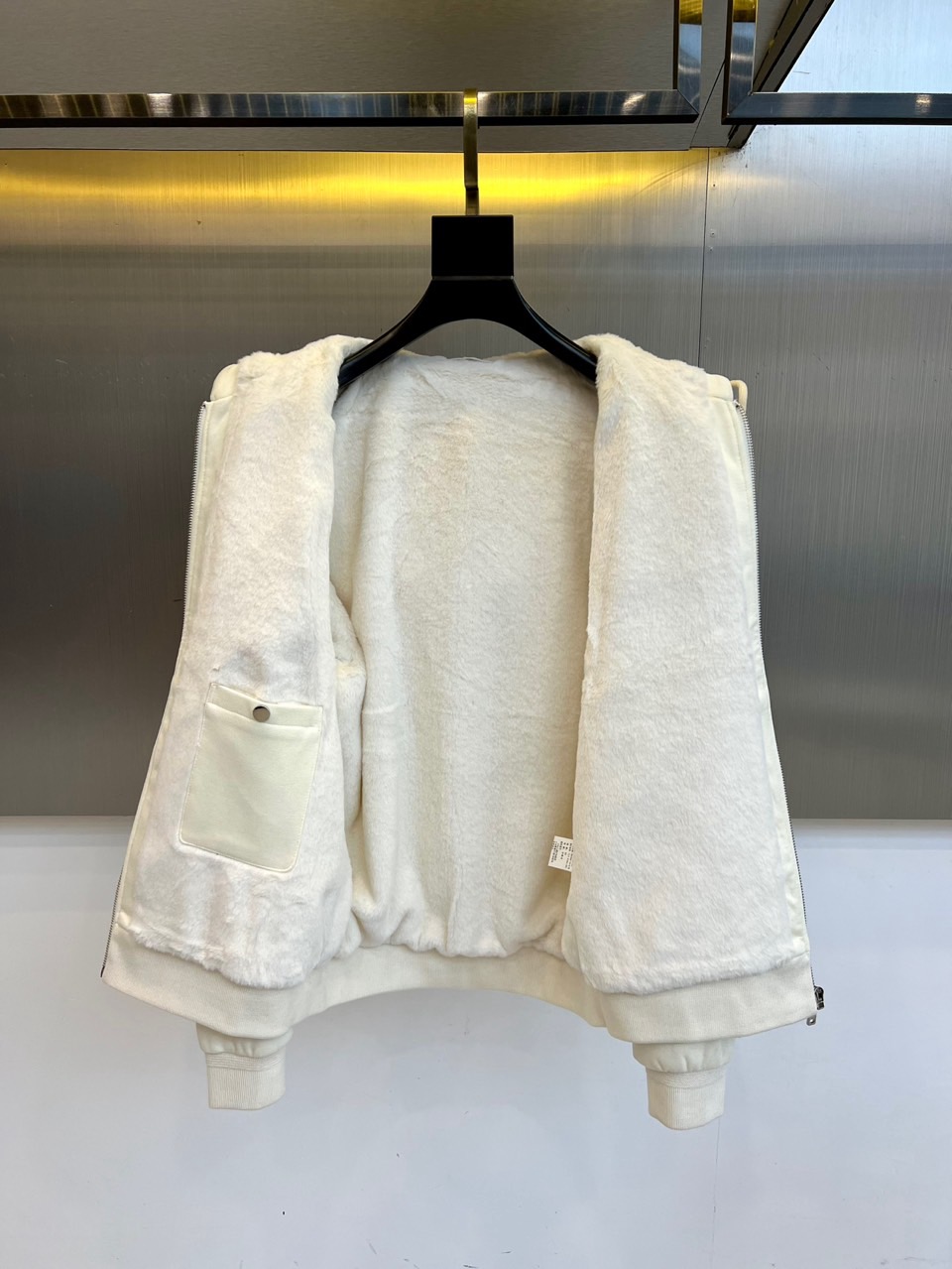 Prad普拉、2025秋冬新品连帽毛绒保暖外套，以极简主义诠释实用美学。这款外套采用立体剪裁的连帽设计，