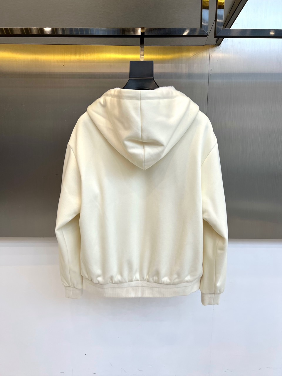 Prad普拉、2025秋冬新品连帽毛绒保暖外套，以极简主义诠释实用美学。这款外套采用立体剪裁的连帽设计，