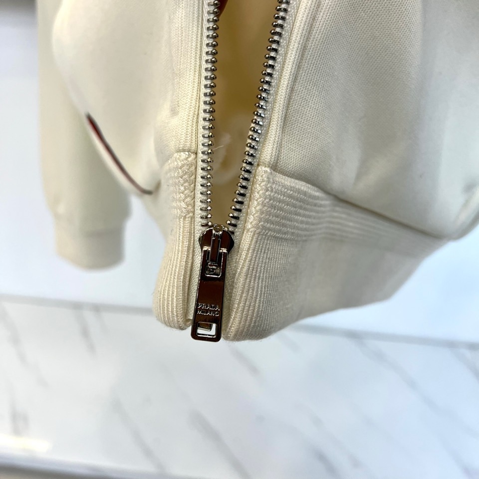 Prad普拉、2025秋冬新品连帽毛绒保暖外套，以极简主义诠释实用美学。这款外套采用立体剪裁的连帽设计，