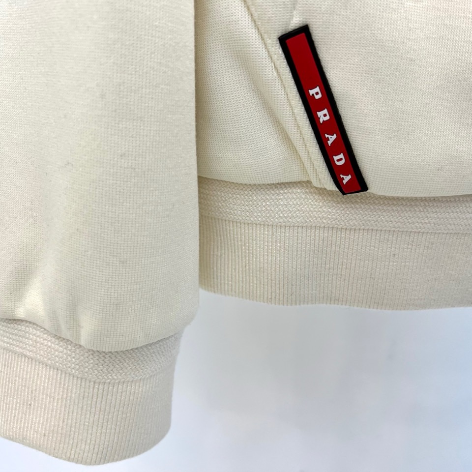 Prad普拉、2025秋冬新品连帽毛绒保暖外套，以极简主义诠释实用美学。这款外套采用立体剪裁的连帽设计，