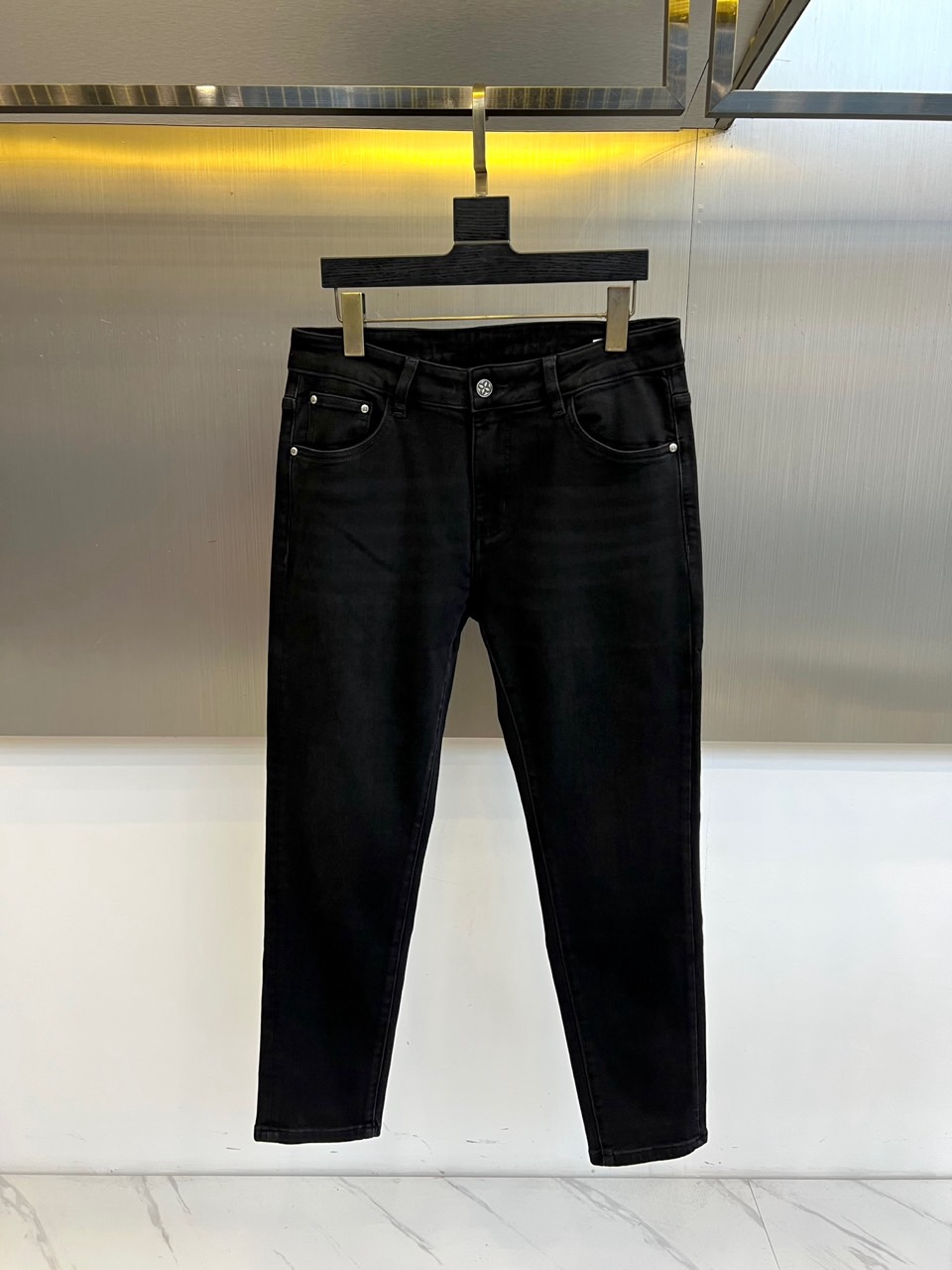 1v威登、2025秋冬新品浮雕徽章牛仔裤。这款黑色牛仔裤采用修身九分裤型设计，后袋饰以品牌标志性浮雕徽章
