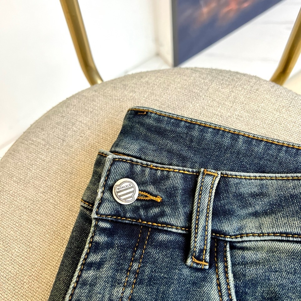 Mon蒙口、2025秋冬新品深蓝色牛仔裤以经典直筒版型演绎现代休闲美学。后袋饰以品牌标志性刺绣徽章，细腻