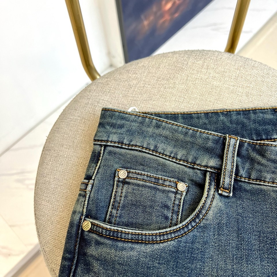 Mon蒙口、2025秋冬新品深蓝色牛仔裤以经典直筒版型演绎现代休闲美学。后袋饰以品牌标志性刺绣徽章，细腻