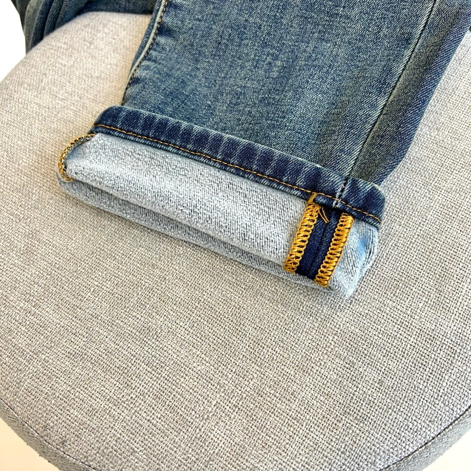 Mon蒙口、2025秋冬新品深蓝色牛仔裤以经典直筒版型演绎现代休闲美学。后袋饰以品牌标志性刺绣徽章，细腻