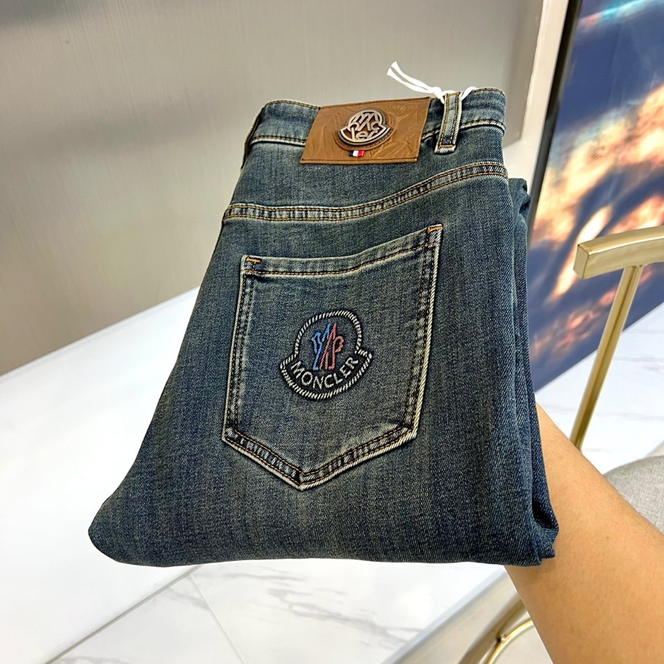 Mon蒙口、2025秋冬新品深蓝色牛仔裤以经典直筒版型演绎现代休闲美学。后袋饰以品牌标志性刺绣徽章，细腻