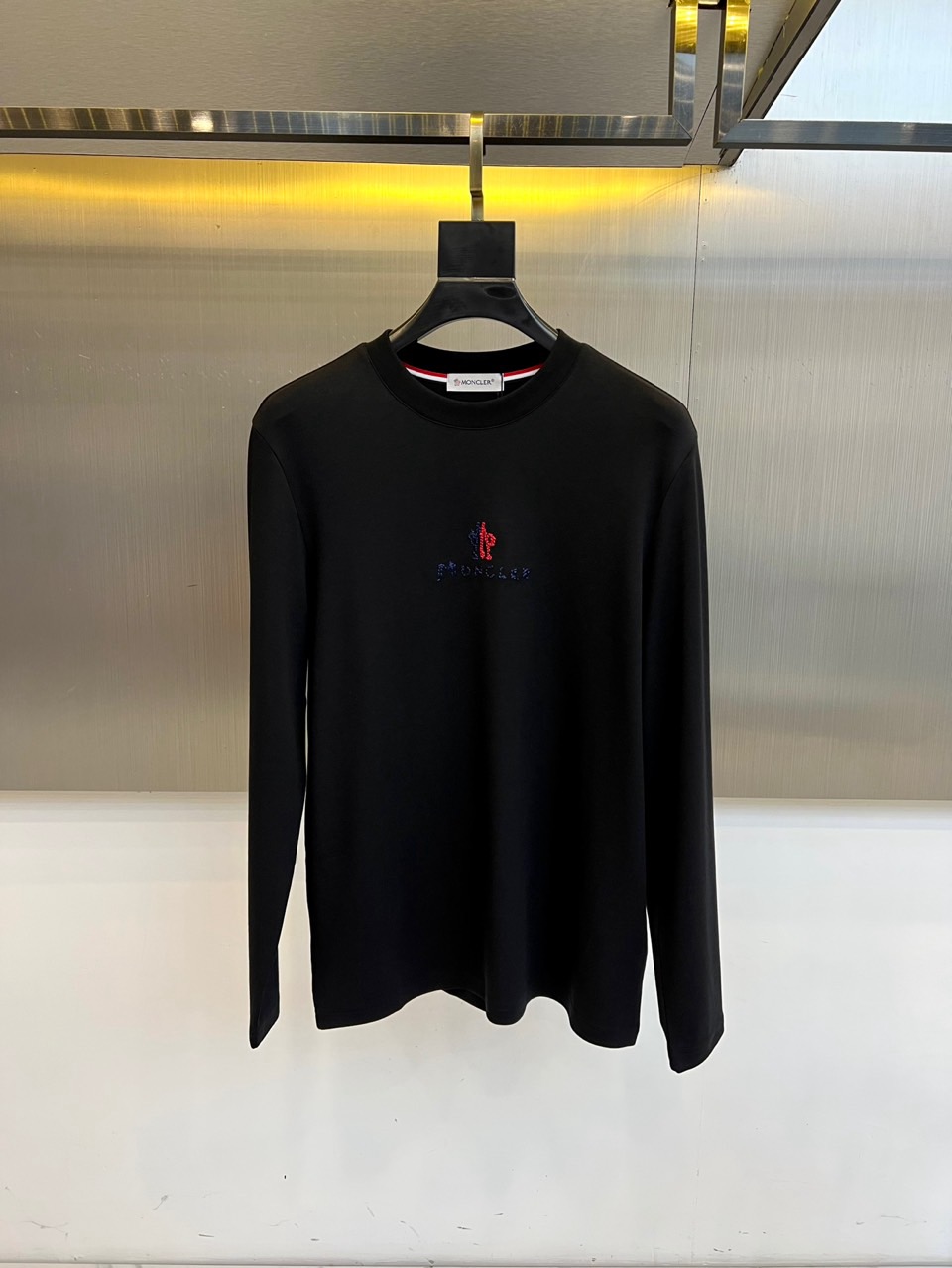 Mon蒙口、2025秋冬新品长袖T恤，以极简圆领设计诠释都市休闲美学。款式采用经典廓形，胸前点缀品牌标志
