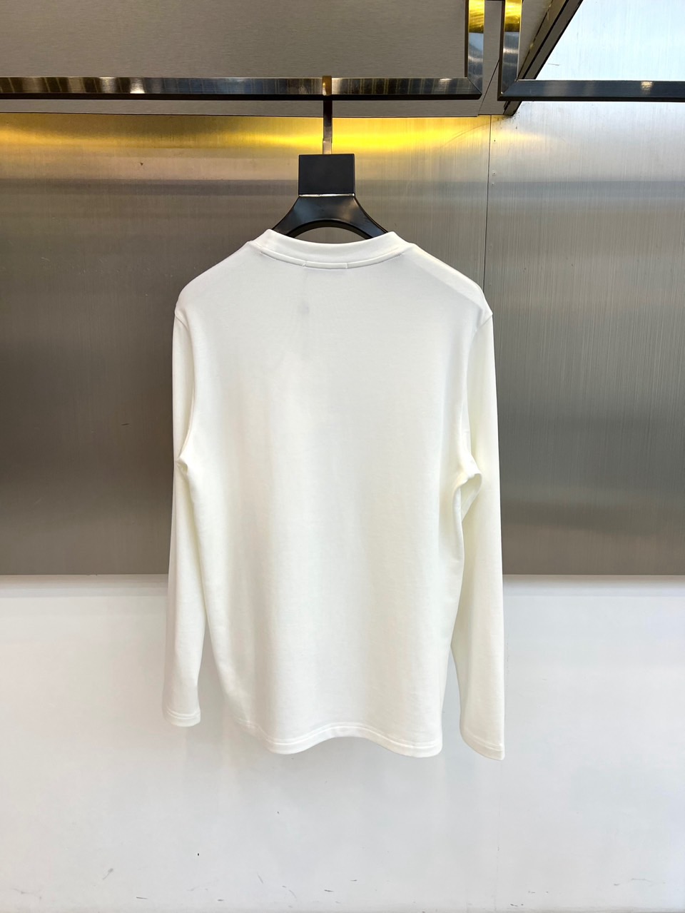 Mon蒙口、2025秋冬新品长袖T恤，以极简圆领设计诠释都市休闲美学。款式采用经典廓形，胸前点缀品牌标志