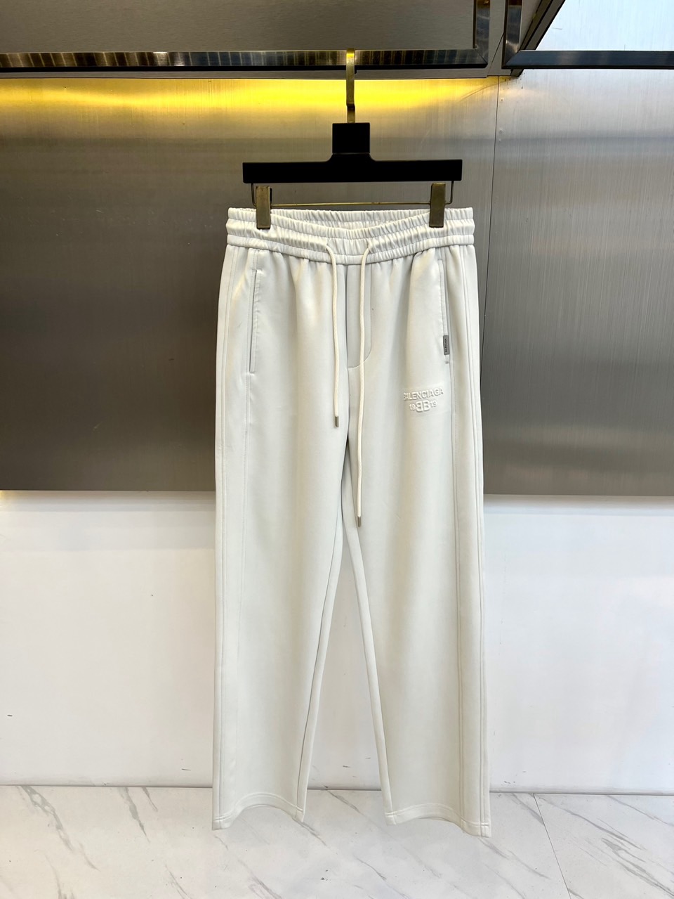 Ba巴黎世家、2025秋冬新品休闲裤，以摩登解构主义重塑当代衣橱美学。选用高品质斜纹棉面料打造雾灰色调，