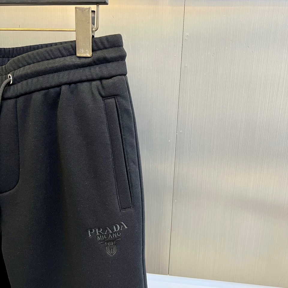 Prad普拉达、2025秋冬新品加绒休闲卫裤，以简约流畅的直筒剪裁，诠释当代休闲服饰的高级质感。裤腰采用