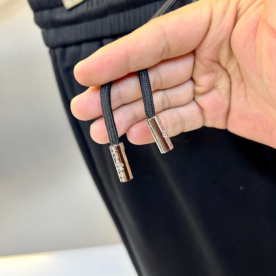 Prad普拉达、2025秋冬新品加绒休闲卫裤，以简约流畅的直筒剪裁，诠释当代休闲服饰的高级质感。裤腰采用