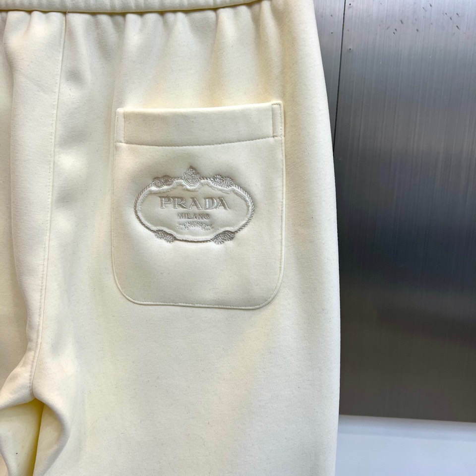 Prad普拉达、2025秋冬新品加绒休闲卫裤，以简约流畅的直筒剪裁，诠释当代休闲服饰的高级质感。裤腰采用