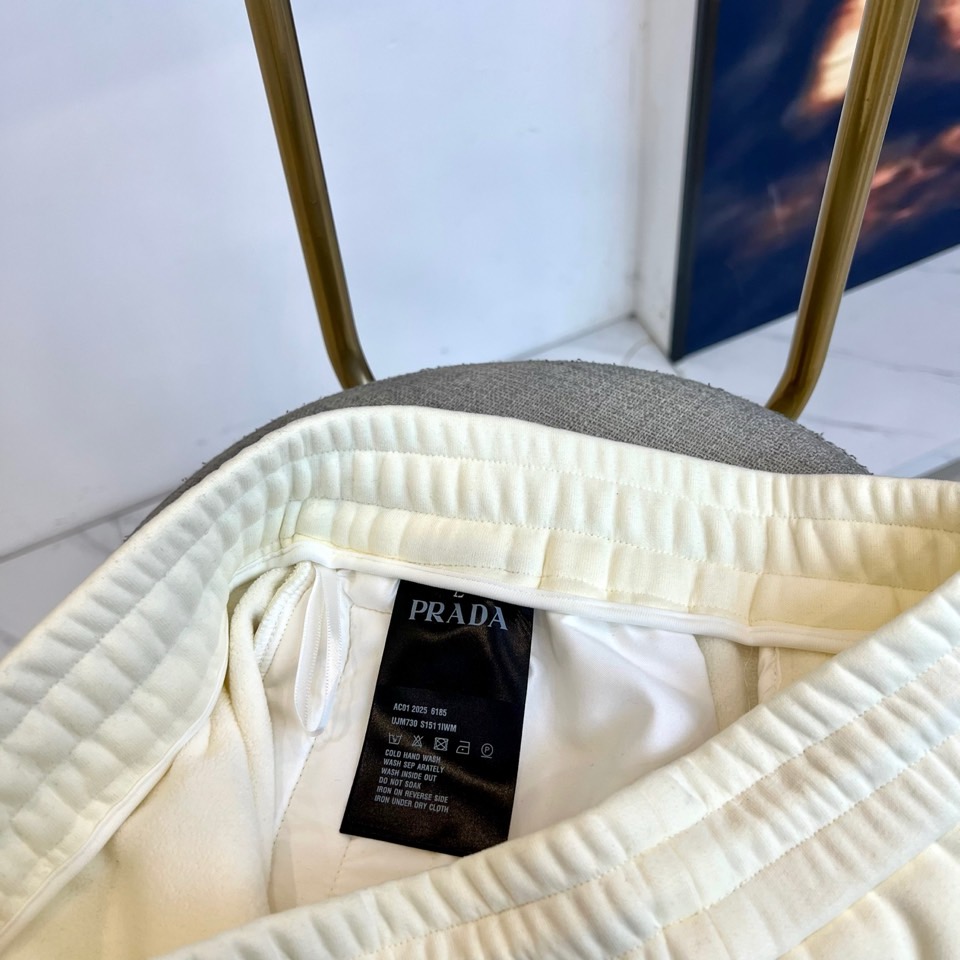 Prad普拉达、2025秋冬新品加绒休闲卫裤，以简约流畅的直筒剪裁，诠释当代休闲服饰的高级质感。裤腰采用