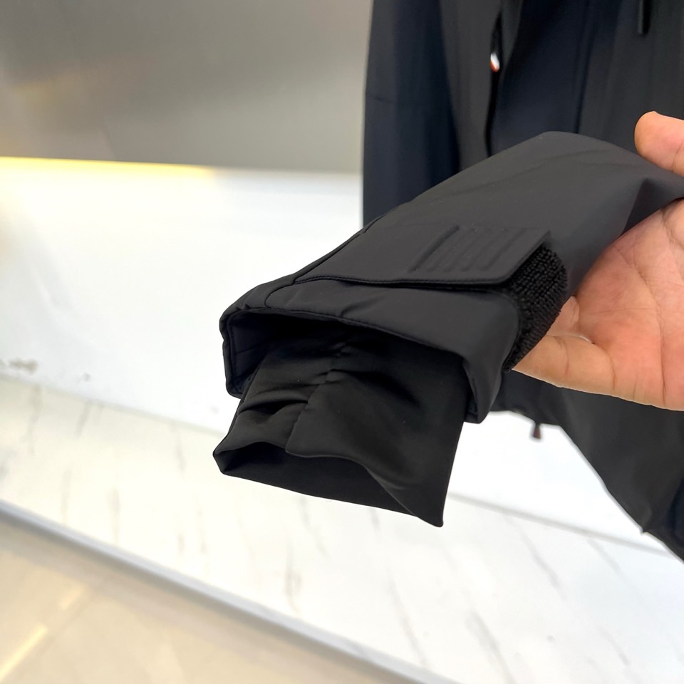 Mon蒙口（纯鹅绒）、2025秋冬新款羽绒服，连帽设计搭配两侧可调节黑色抽绳，兼顾实用功能与流畅轮廓。衣