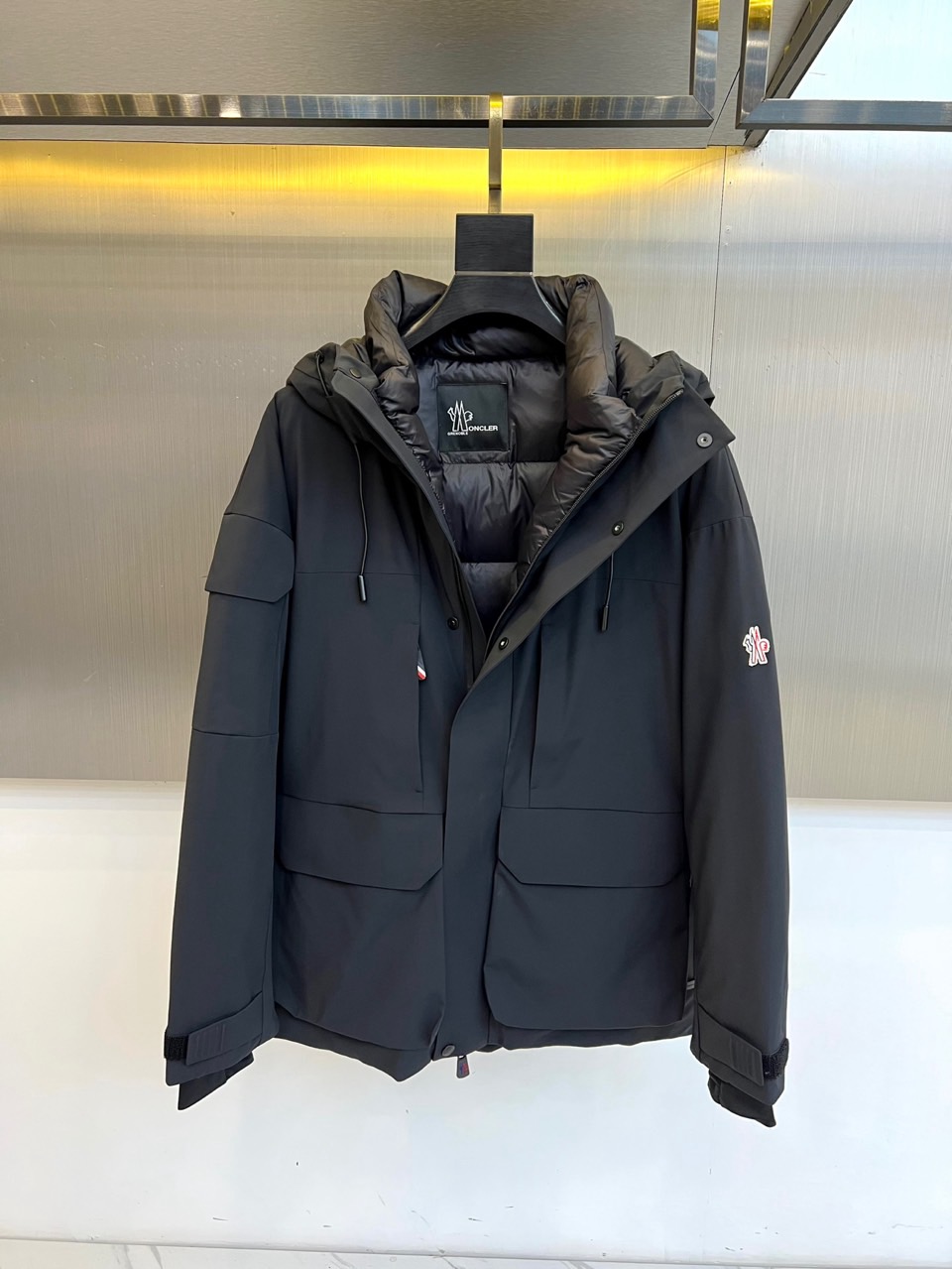 Mon蒙口（纯鹅绒）、2025秋冬新款羽绒服，连帽设计搭配两侧可调节黑色抽绳，兼顾实用功能与流畅轮廓。衣