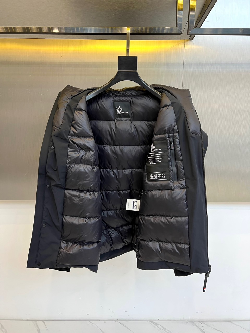 Mon蒙口（纯鹅绒）、2025秋冬新款羽绒服，连帽设计搭配两侧可调节黑色抽绳，兼顾实用功能与流畅轮廓。衣