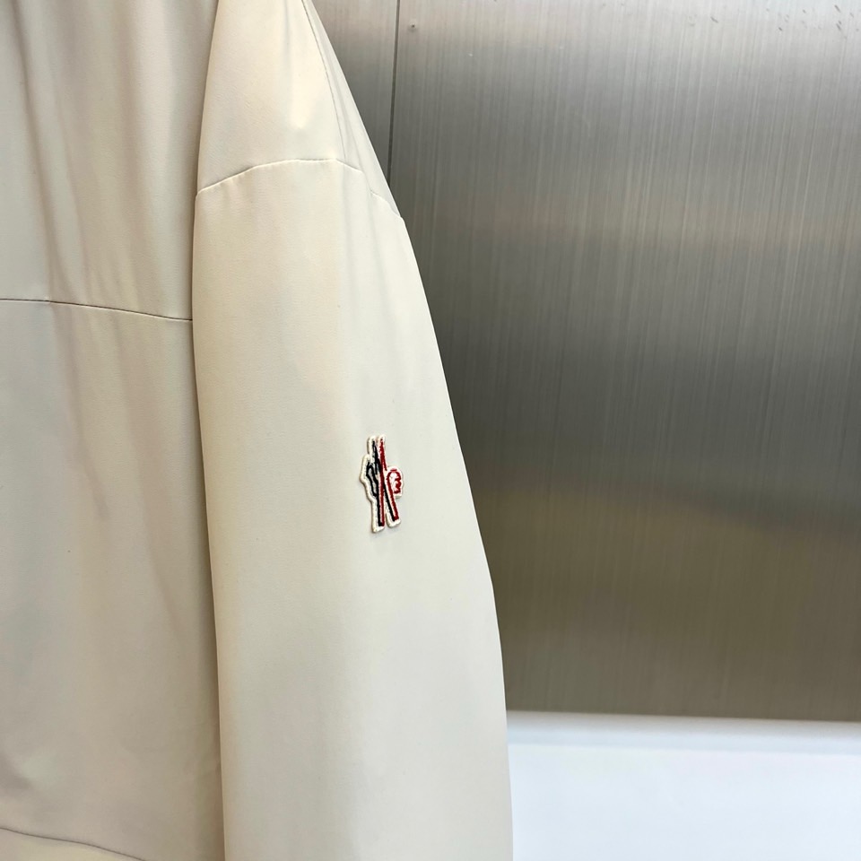 Mon蒙口（纯鹅绒）、2025秋冬新款羽绒服，连帽设计搭配两侧可调节黑色抽绳，兼顾实用功能与流畅轮廓。衣