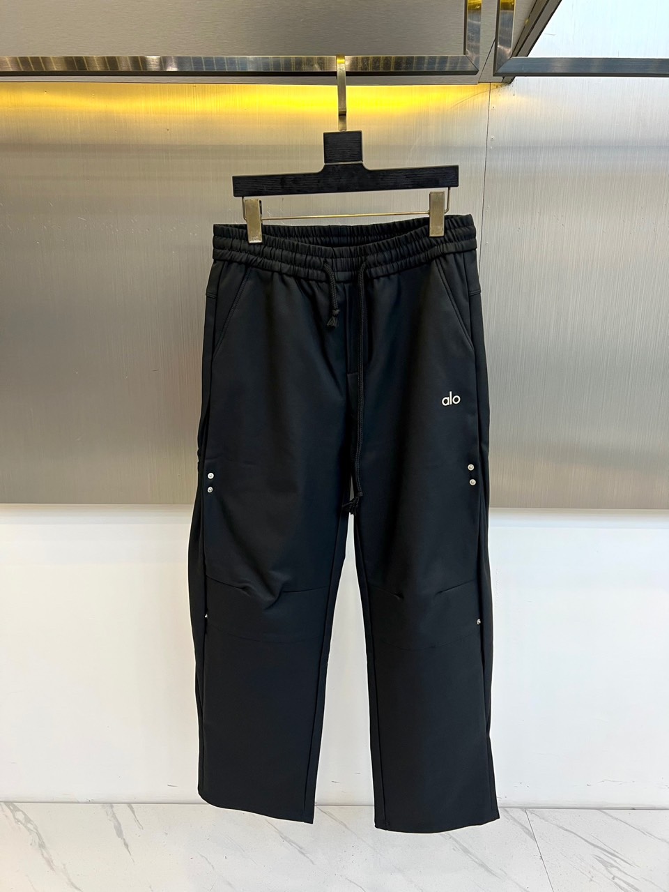 NO:684310,[AO | Dark functional casual pants] Black elastic waistband | Silver rivet decoration | Brand logo on side legs. Matte black simple silhouette. Made of classic black matte fabric, draped smoothly, showing low-key and versatile daily attributes, suitable for many occasions. Elastic drawstring waistband. Built-in elastic waistband with same-color drawstring, which can be freely adjusted for comfort and neat silhouette. Rivet-decorated pockets  The edges of the diagonal pockets on both sides are embellished with silver rivets, injecting tough details into the pure black tone, enhancing the visual hierarchy and street functionality. Side leg brand logo The white 'AO' brand logo is printed on the outside of the left leg. The simple font contrasts sharply with the black fabric, low-key highlighting the brand identity. Suitable for matching simple tops or street style items, decorated with black and silver colors and details, to create a daily look that is both practical and stylish. M-3XL (please state your height and weight when placing an order),,19860909【AO｜暗黑机能休闲裤】 黑色松紧腰头｜银色铆钉装饰｜侧腿品牌标识 哑光黑简约廓形 选用经典黑色哑光面料,垂顺利落,呈现低调百搭的日常属性,适配多场合穿着. 松紧抽绳腰头 内置弹性腰围搭配同色抽绳,可自由调节松紧,兼顾舒适度与利落轮廓. 铆钉装饰口袋 两侧斜插口袋边缘点缀银色铆钉,为纯黑基调注入硬朗细节,提升视觉层次与街头机能感. 侧腿品牌标识 左腿外侧印有白色“AO”品牌标识,简洁字体与黑色面料形成鲜明对比,低调彰显品牌身份. 适合搭配简约上装或街头风格单品,以黑银配色与细节装饰,打造兼具实用性与型格的日常造型.M-3XL（下单请报身高体重腰围）,,,Men's clothing