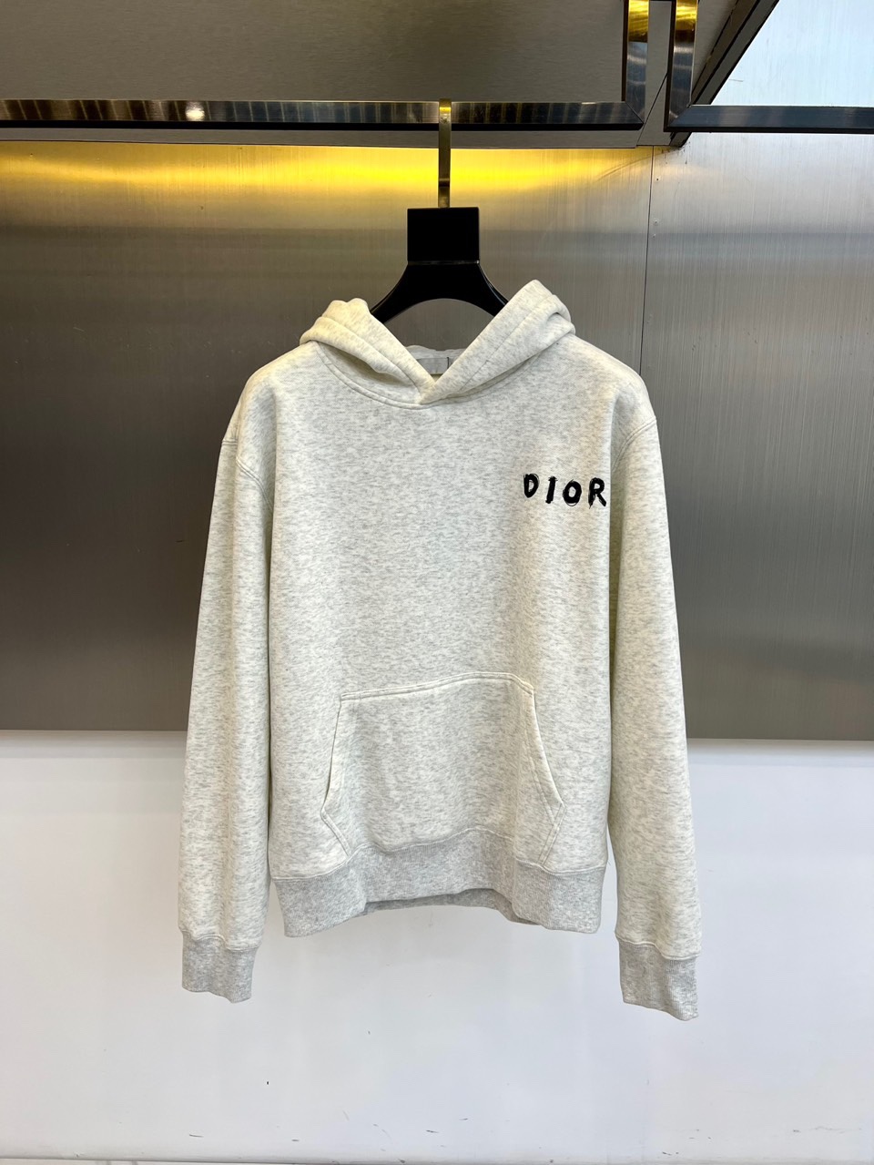 NO:684311,Dior, the new 2025 autumn and winter DIOR light gray hooded sweatshirt, uses soft and thick fabrics to present a simple and advanced daily style. The chest is decorated with the classic black 'DIOR' embroidered logo, with exquisite and unobtrusive details. The sweatshirt adopts a loose hooded version, with a practical kangaroo pocket and comfortable ribbed cuffs and hem, and the cuffs are lined with velvet  treatment to enhance warmth in autumn and winter. The overall design takes into account a casual feel and high-end texture, suitable for daily layering or wearing alone, adding low-key yet recognizable fashion items to the autumn and winter wardrobe. S-4XL (model 173-140 pounds upper body size M),, dior, hoodie, sweatshirts, hats,19860909Dior、2025秋冬新款DIOR浅灰色连帽卫衣,以柔软厚实面料呈现简约高级的日常风格.胸前饰有经典黑色“DIOR”刺绣标识,细节精致而不张扬.卫衣采用宽松连帽版型,搭配实用袋鼠兜与舒适罗纹袖口及下摆,袖口内衬加绒处理,增强秋冬保暖度.整体设计兼顾休闲感与高级质地,适合日常叠穿或单穿,为秋冬衣橱增添低调而具辨识度的时尚单品.S-4XL（模特173-140斤上身M码）,,dior,hoodie,sweatshirts,hats,,Men's clothing