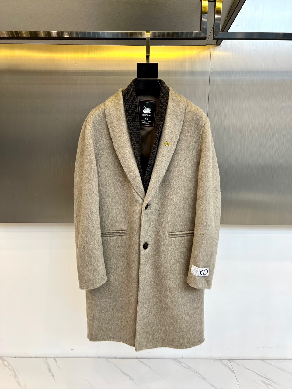 Dio迪奥、2025秋冬新品，以浅灰色毛呢大衣演绎低调奢华。款式采用经典西装领与双排扣设计，线条利落流畅