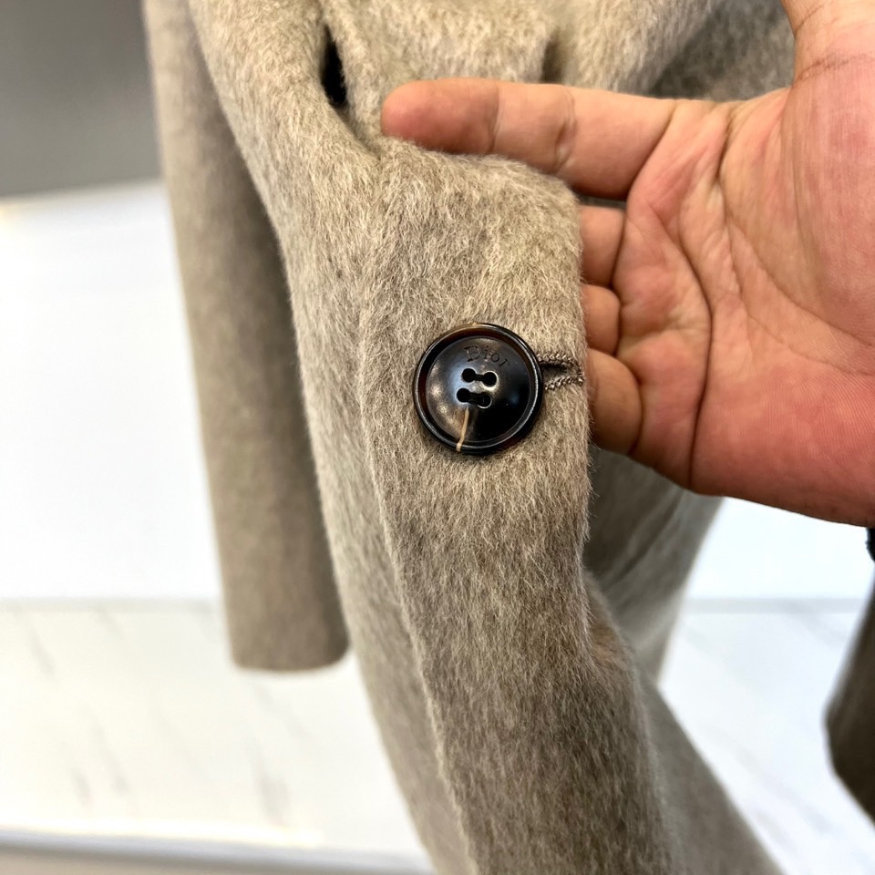 Dio迪奥、2025秋冬新品，以浅灰色毛呢大衣演绎低调奢华。款式采用经典西装领与双排扣设计，线条利落流畅