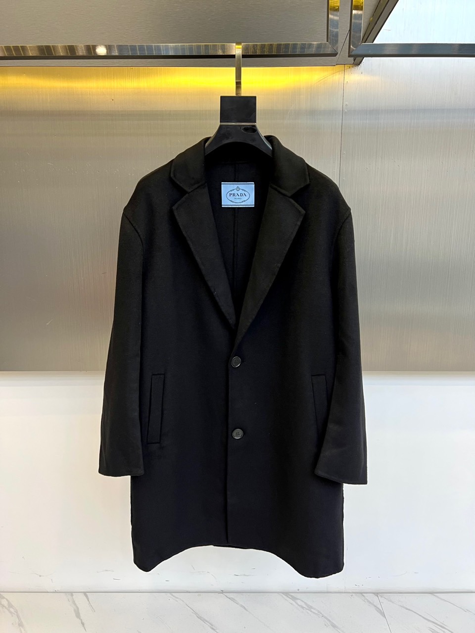 Prad普拉达、2025秋冬新品男士大衣，以经典黑色演绎永恒奢华的现代美学。这款大衣采用90%羊毛与10