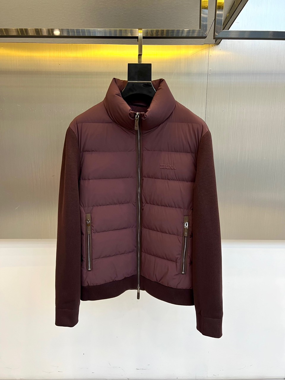 Zegna杰尼亚、2025秋冬新品立领羽绒服，立领设计搭配精密拉链开合系统。创新采用羽绒与针织拼接结构：