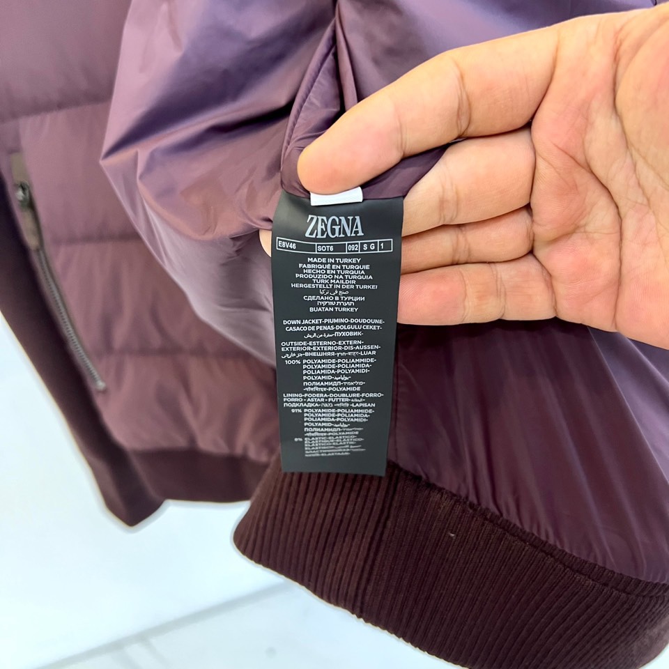 Zegna杰尼亚、2025秋冬新品立领羽绒服，立领设计搭配精密拉链开合系统。创新采用羽绒与针织拼接结构：