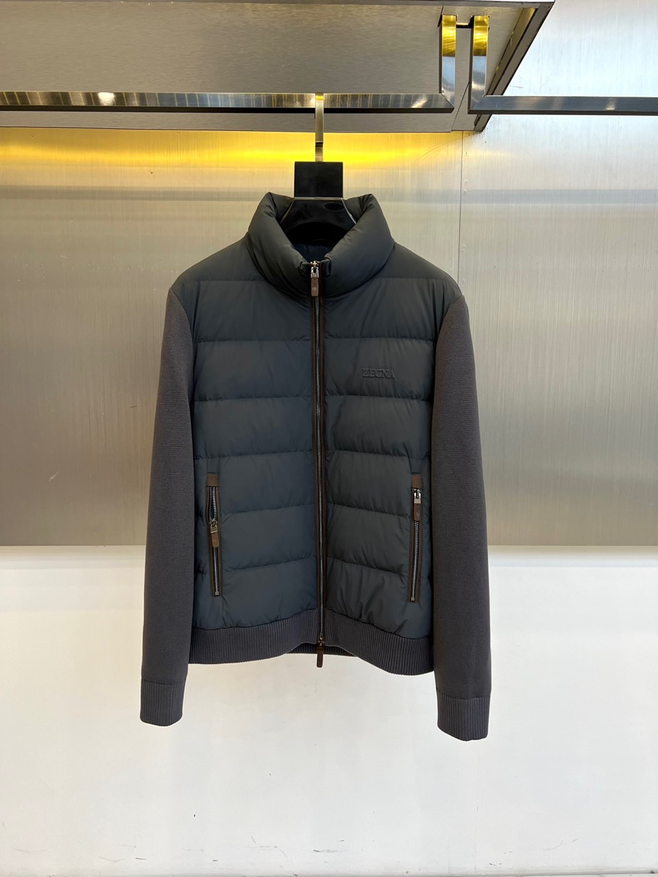 Zegna杰尼亚、2025秋冬新品立领羽绒服，立领设计搭配精密拉链开合系统。创新采用羽绒与针织拼接结构：