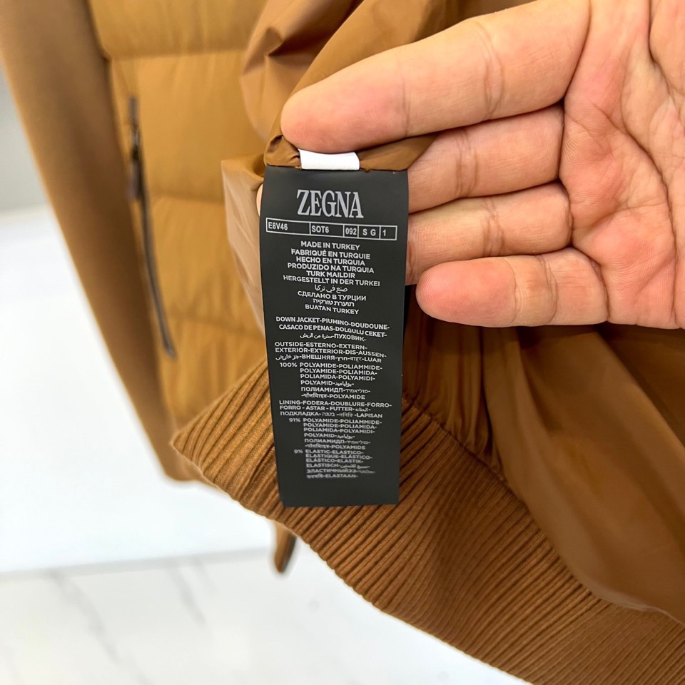 Zegna杰尼亚、2025秋冬新品立领羽绒服，立领设计搭配精密拉链开合系统。创新采用羽绒与针织拼接结构：