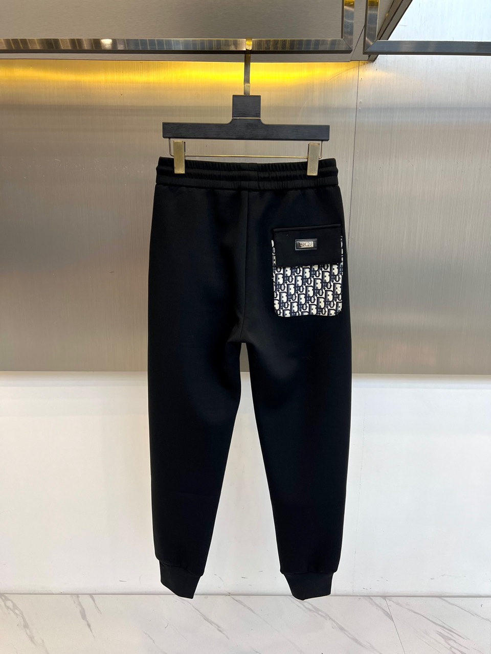 Dio迪奥、2025秋冬新品男士休闲裤以经典黑色演绎现代绅士风尚。这款长裤采用修身直筒剪裁，腰部配备可调