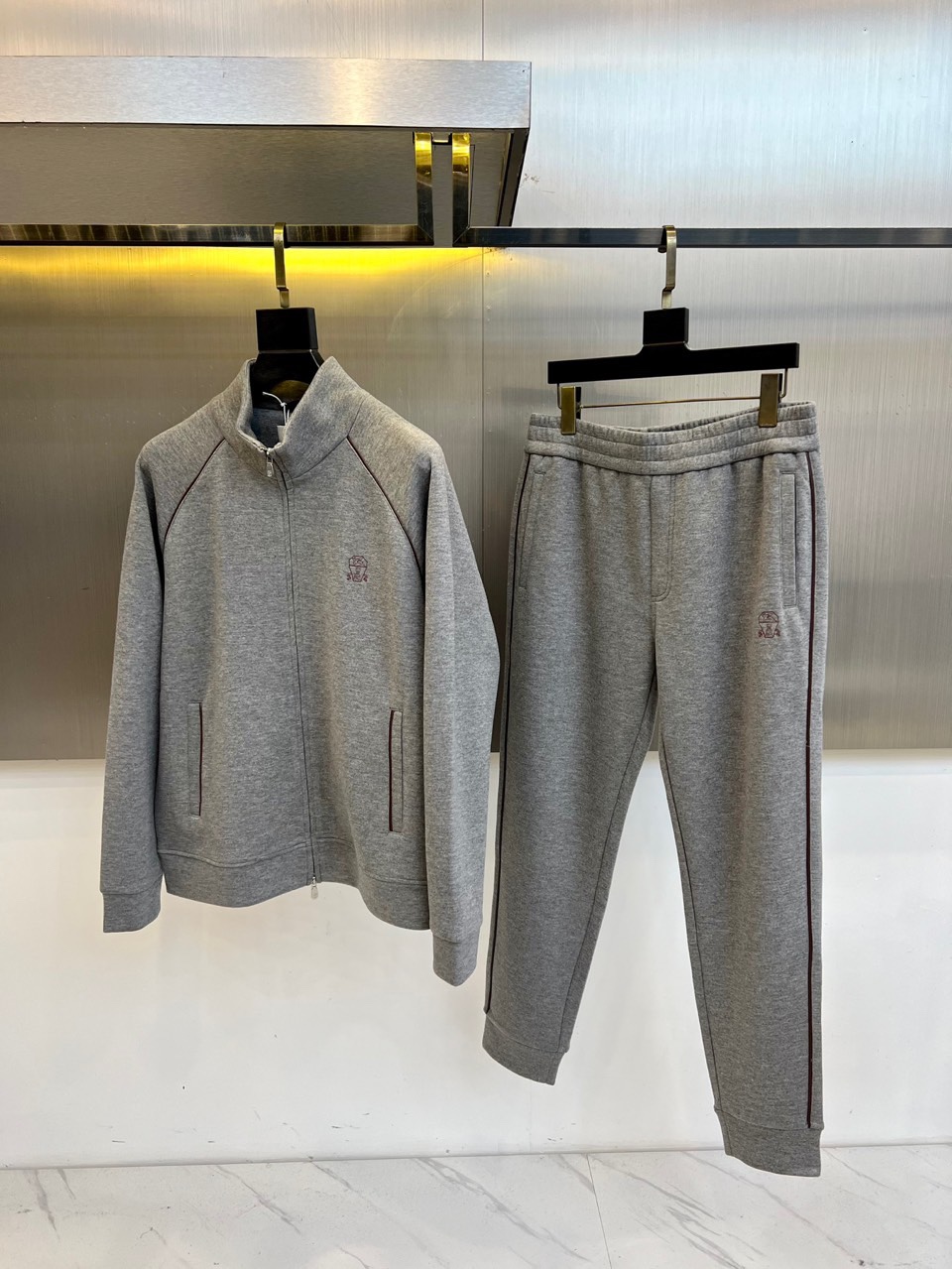 NO:703161,Brunello  Cucinelli-BC - new autumn and winter wool air layer sports suit. This sports suit consists of a stand-up collar zipper jacket and legged trousers of the same color. The left chest is embellished with the brand's exquisite embroidered logo. The jacket adopts a smooth zipper opening and closing system, and hidden pockets on both sides keep the lines smooth; the waistband of the trousers is designed with elastic drawstrings, and the sides of the trouser legs are decorated with ultra-fine stripes to echo the details of the jacket. The fabric is blended from Italy's top textile workshops.  The material is made of professional dry cleaning care logo to highlight the luxurious quality. The stand-up collar design can prevent wind and keep warm, and the overall tailoring takes into account freedom of movement and slimming effect. The main tone of light gray presents a low-key and high-end feel. It can be worn with sports shoes to show vitality during morning jogging, or can be worn with a coat to create a high-end casual look. It explains the brand's design philosophy of integrating Italian luxury craftsmanship into daily wear. 48-56 (model is 173, 143 pounds, upper body size 50), brunello  cucinelli,sneakers,jackets & coats,19860909Brunello Cucinelli-BC-秋冬新品羊毛空气层运动套装,这款运动套装以立领拉链外套与同色系束脚长裤组成整体造型,左胸点缀品牌精致刺绣标识.外套采用顺滑拉链开合系统,两侧隐藏式口袋保持线条流畅；长裤腰部采用弹性抽绳设计,裤腿侧边装饰极细条纹与外套细节呼应.面料选用意大利顶级纺织工坊出品的混纺材质,通过专业干洗护理标识彰显奢华品质.立领设计可防风保暖,整体剪裁兼顾运动自由度与修身效果.浅灰主调呈现低调高级感,既可晨跑时搭配运动鞋展现活力,也可外搭大衣打造高端休闲造型.诠释了品牌将意式奢华工艺融入日常穿着的设计哲学.48-56（模特173,143斤上身50码）,,brunello cucinelli,sneakers,jackets & coats,,Men's clothing