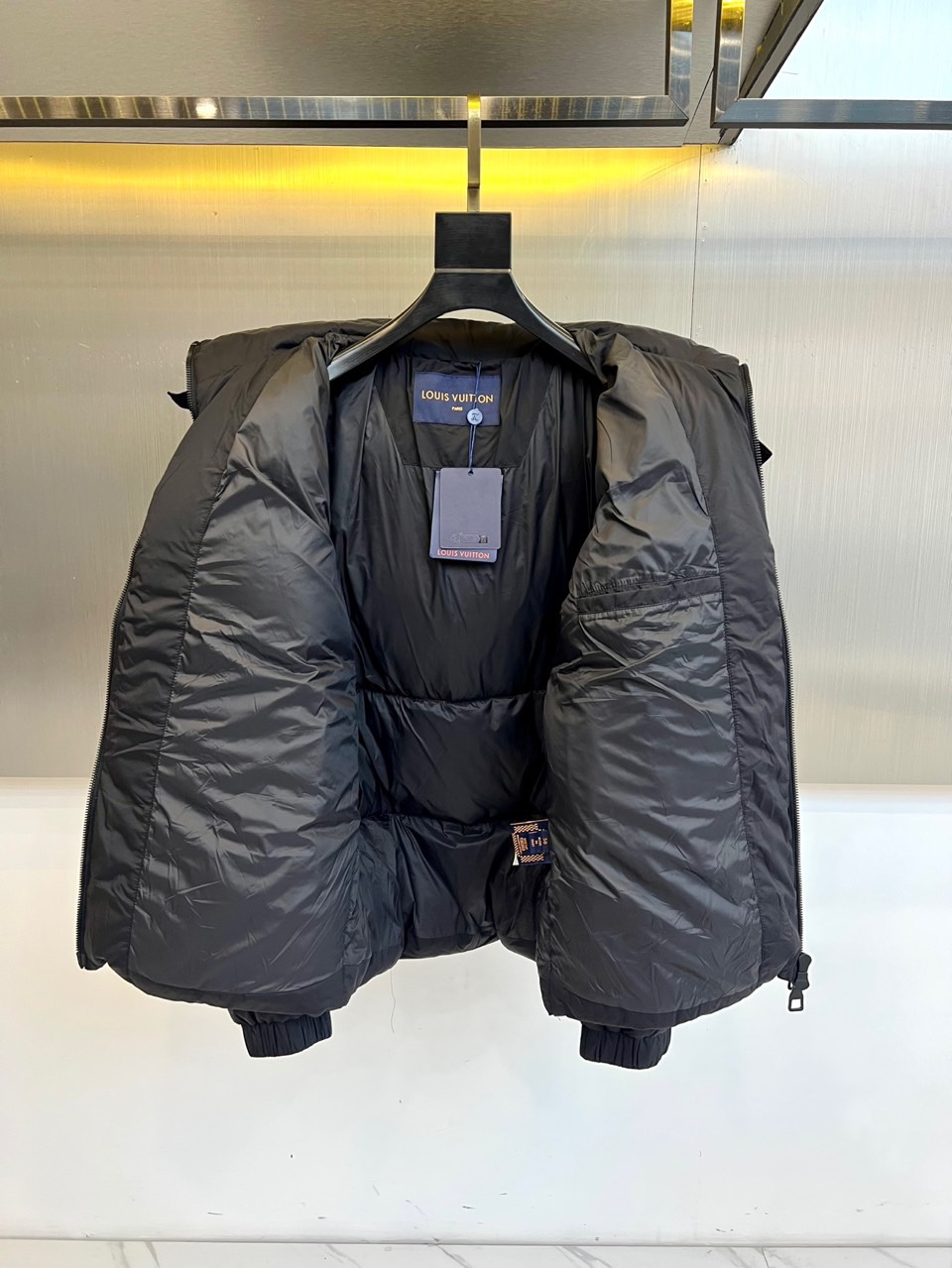 1v威登、2025秋冬新品黑色羊毛🐑羽绒服，以连帽设计演绎现代奢华。领口处点缀的纽扣细节既增强实用性，又