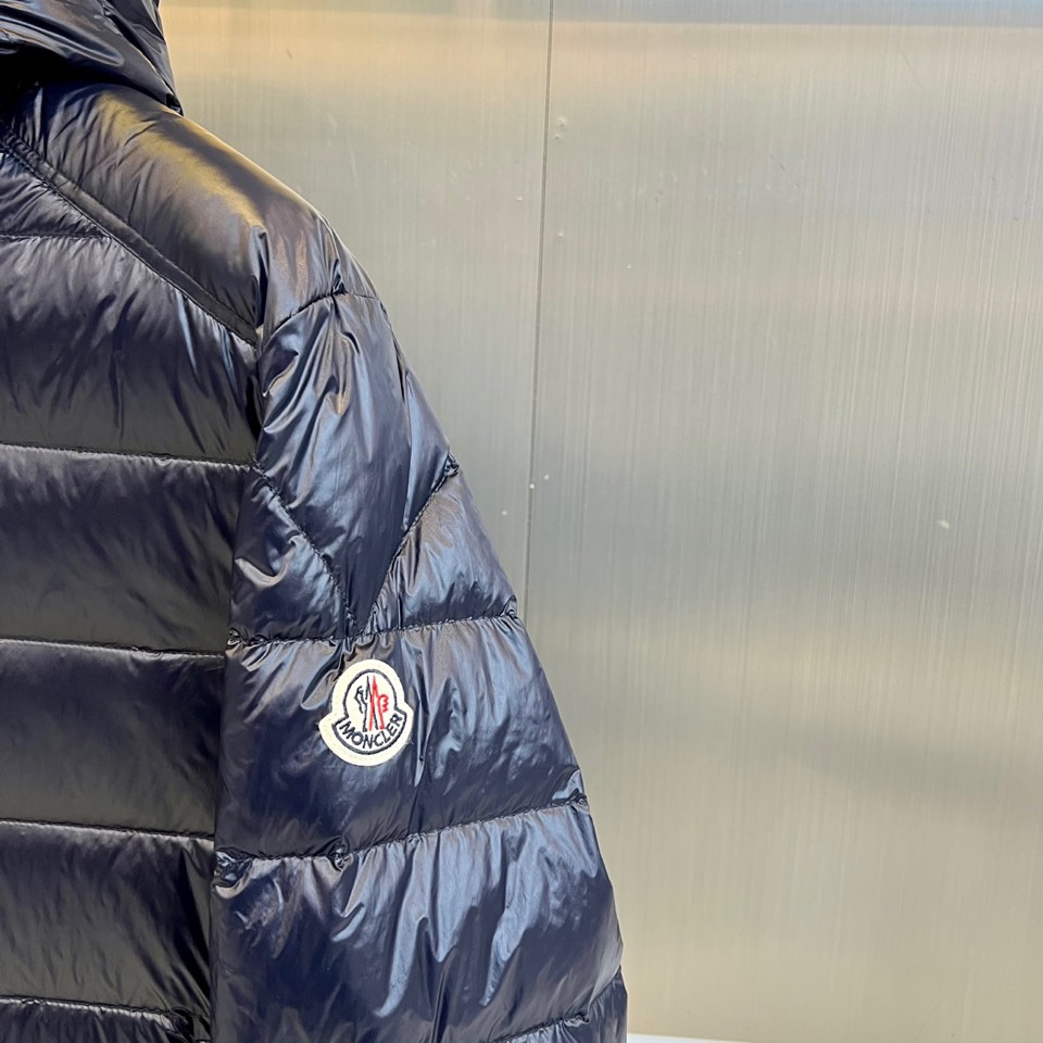 Mon蒙口（白鹅绒）、2025秋冬新品羽绒服，以深邃的色调演绎现代功能美学。款式采用连帽设计，帽檐配备可