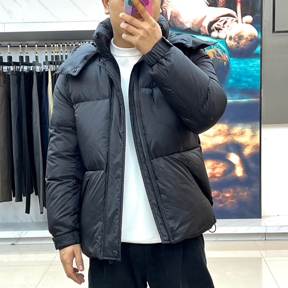 Prad普拉达、2025秋冬新品黑色羽绒服，以经典黑色重塑都市冬日美学。款式采用简约连帽设计，帽部点缀实