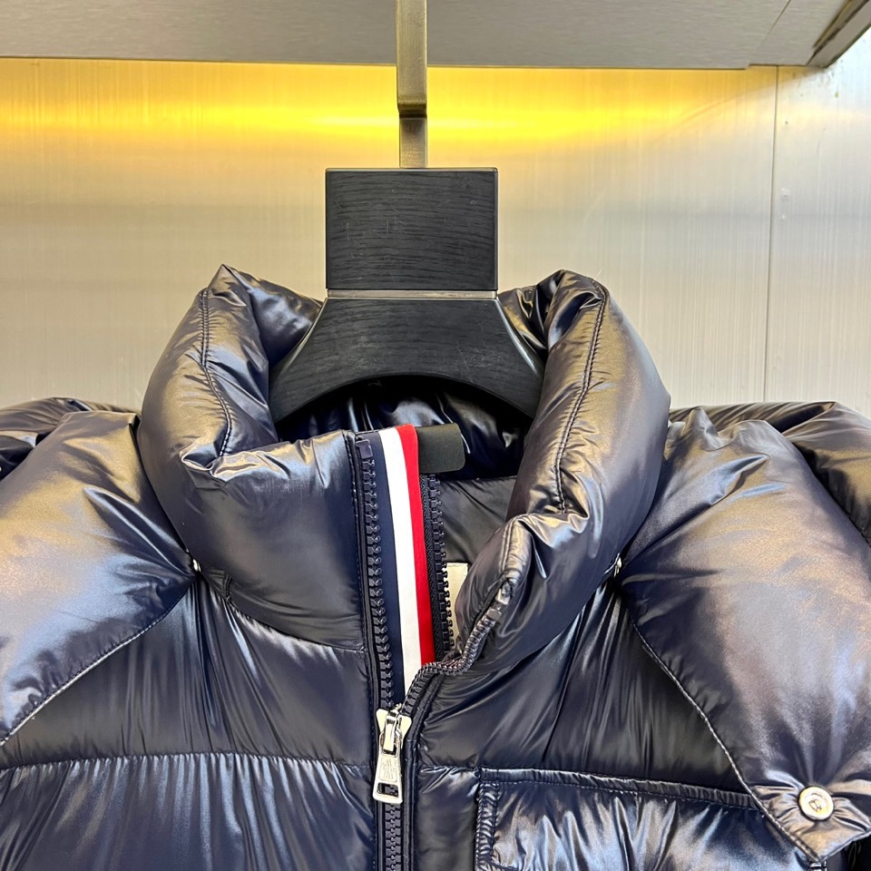 Mon蒙口（鹅绒）、2025秋冬新品羽绒服，以深蓝色亮面短款设计诠释现代都市机能美学。款式采用利落箱型剪