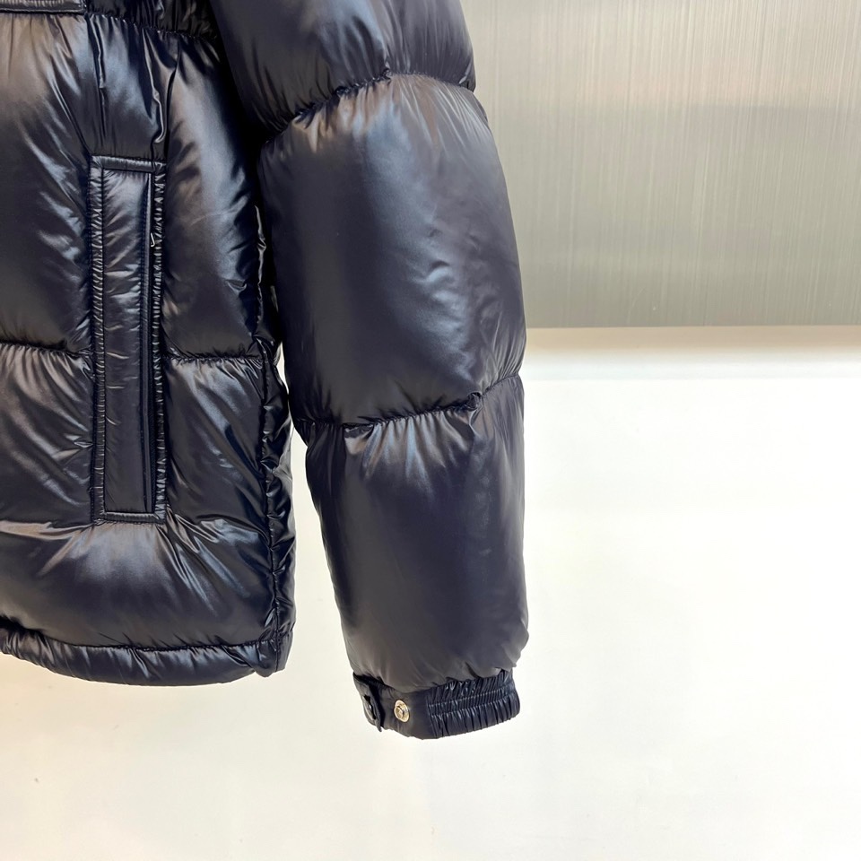 Mon蒙口（鹅绒）、2025秋冬新品羽绒服，以深蓝色亮面短款设计诠释现代都市机能美学。款式采用利落箱型剪