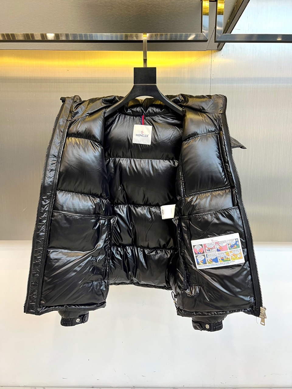 Mon蒙口（鹅绒）、2025秋冬新品羽绒服，以深蓝色亮面短款设计诠释现代都市机能美学。款式采用利落箱型剪