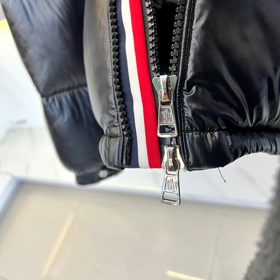 Mon蒙口（鹅绒）、2025秋冬新品羽绒服，以深蓝色亮面短款设计诠释现代都市机能美学。款式采用利落箱型剪