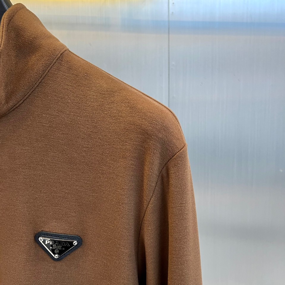 Prad普拉达、2025秋冬新品半高领T恤以极简设计诠释低调奢华。采用59%粘纤、33%腈纶与8%氨纶的