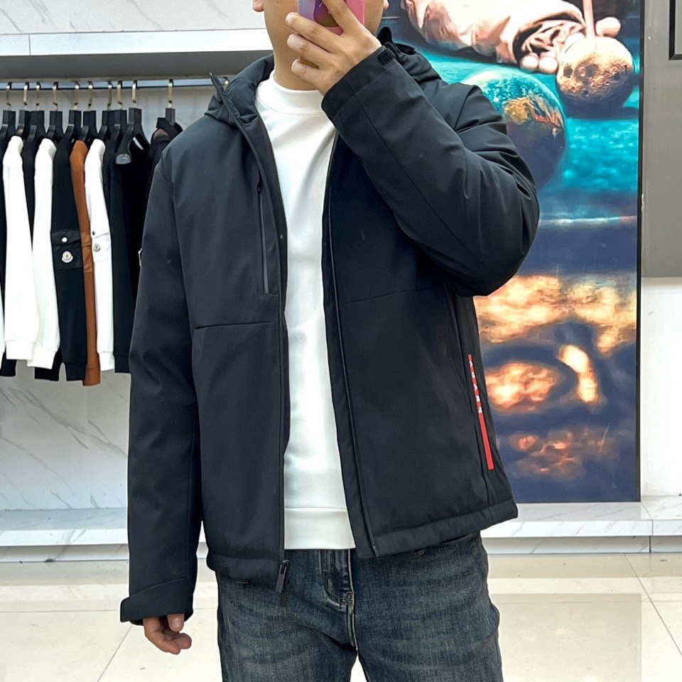 Prad普拉达（白鹅绒）、2025秋冬新品羽绒服，连帽设计搭配利落的直线条轮廓，通过精准的绗缝工艺勾勒出