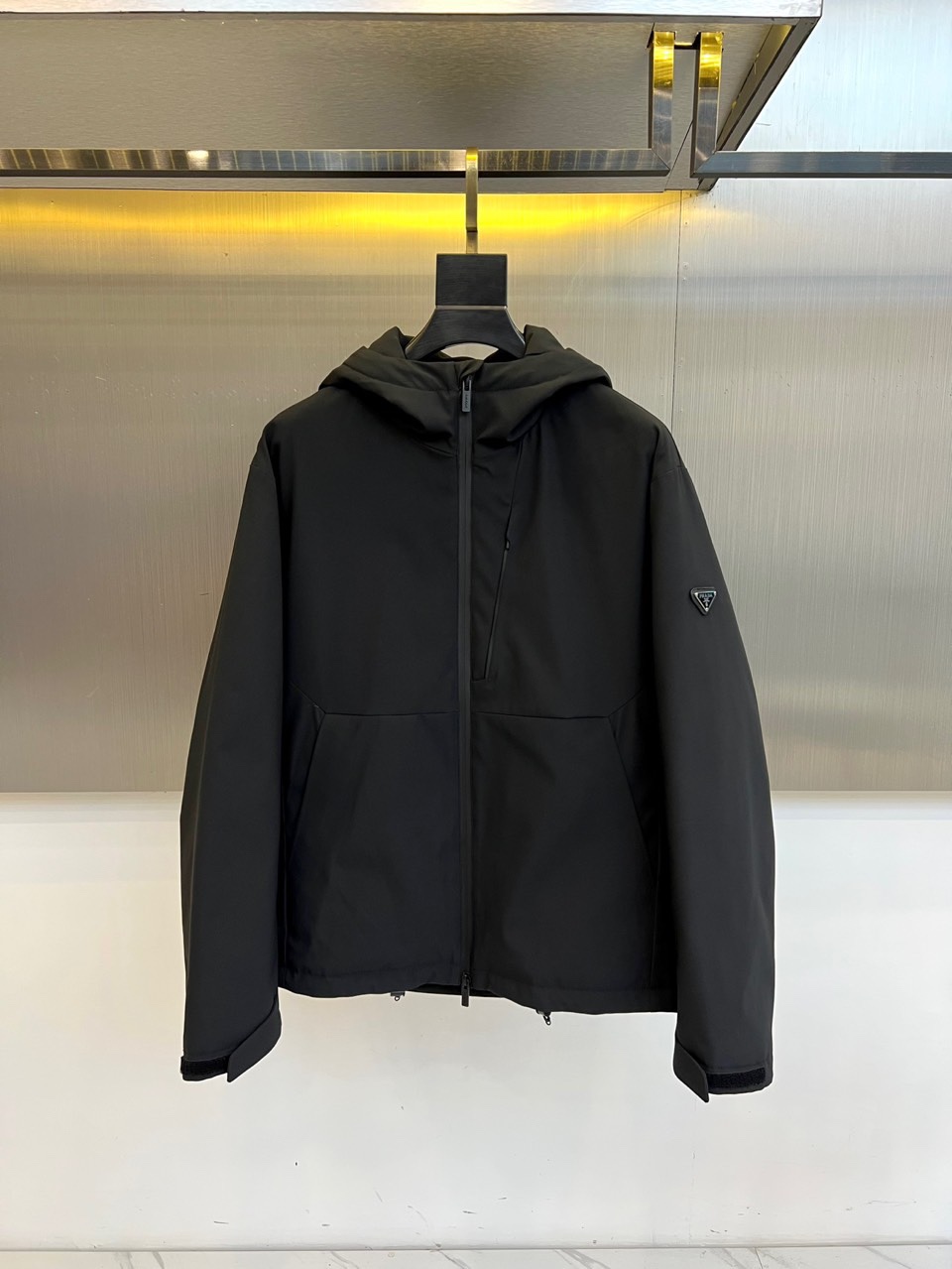 Prad普拉达（白鹅绒）、2025秋冬新品羽绒服，连帽设计搭配利落的直线条轮廓，通过精准的绗缝工艺勾勒出