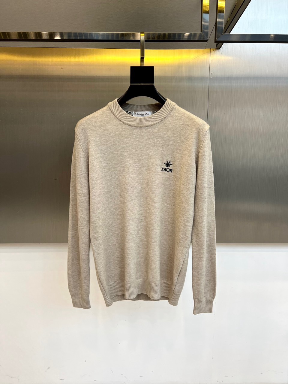 NO:712014,Christian Dior, 2025 autumn and winter new round-neck sweater, adopts a classic round-neck design. The left chest is embellished with the brand's iconic black embroidered logo. The delicate stitching outlines the exquisite details of the DIOR letters and classic totems. The fabric is strictly made of wool, and the Italian manufacturing process ensures excellent quality. The label clearly indicates the professional care guide. Do not wash, do not chlorine bleach, do not tumble dry. It is recommended to iron at low temperature and professional gentle dry cleaning.  Its tailoring pays attention to slimming effect and natural drape, and the wool material brings a soft and skin-friendly wearing experience. It can be worn alone with suit pants to show a business casual style, or it can be combined with a skirt to create an elegant everyday look. From high-end social occasions to daily commuting, this sweater uses the natural texture of pure wool and iconic embroidery  Craftsmanship has become a fashion carrier that connects the brand's century-old heritage with modern life, interpreting Dior's ultimate pursuit of materials and craftsmanship. M-4XL (model weighs 173,143 pounds, upper body size L),, dior, dior, skirts, sweaters, business  suit,19860909Christian Dior迪奥、2025秋冬新品圆领毛衣,款式采用经典圆领设计,左胸点缀品牌标志性黑色刺绣标识,细腻针脚勾勒出DIOR字母与经典图腾的精致细节.面料严格选用羊毛材质,意大利制造工艺确保卓越品质,标签明确标注专业养护指南不可水洗、不可氯漂、不可转筒干燥,建议低温熨烫与专业缓和干洗. 其剪裁注重修身效果与自然垂坠感,羊毛材质带来柔软亲肤的穿着体验.可单独搭配西装裤展现商务休闲风范,亦可与半裙组合营造优雅日常造型.从高级社交场合到日常通勤,这款毛衣以纯羊毛的天然质感与标志性刺绣工艺,成为连接品牌百年传承与现代生活的时尚载体,诠释迪奥对材质与工艺的极致追求.M-4XL（模特173,143斤上身L码）,,dior,dior,skirts,sweaters,business suit,,Men's clothing