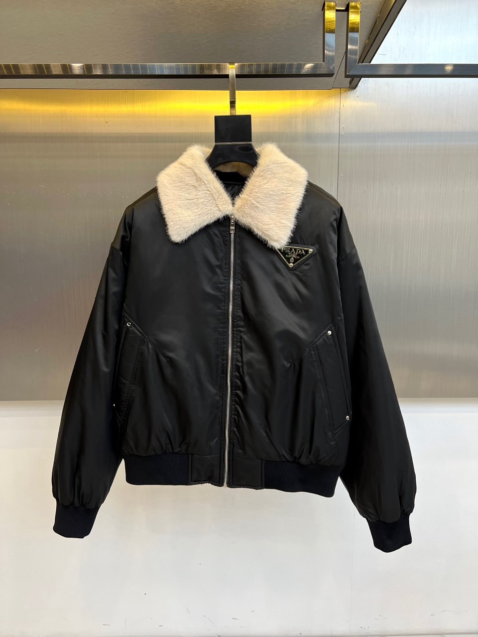 NO:712024,Prad, the new jacket for autumn and winter 2025, uses deep blue tones to interpret modern urban aesthetics. The style adopts a neat short silhouette, combined with a practical zipper closure design, and the collar is decorated with a circle of rich and soft white plush, which not only provides excellent  The warmth retention adds a touch of luxury. The brand's classic triangular metal logo is embellished on the left chest, low-key highlighting the noble status. The tightening of the cuffs and hem not only ensures wind protection and warmth, but also optimizes the overall lines and highlights the capable temperament.  In terms of style, this jacket perfectly combines Prada's rationalism and exquisite style. Its fabric is made of high-tech materials, with excellent stiffness and good protective performance, and the details show exquisite Italian craftsmanship. Whether it is paired with a simple inner layer to create a daily commuting look, or combined with high-quality bottoms for casual occasions, it is  It can become a key item to improve the overall fashion, showing a calm and elegant style. This jacket is a wise choice that combines functionality and fashion, interpreting the practical philosophy of modern luxury wardrobe. 48-56 (model is 173, 143 pounds, upper body size 50),, prada, prada, jackets  & coats,19860909Prad普拉达、2025秋冬新品夹克,以深邃的蓝色调演绎现代都市美学.款式采用利落的短款廓形,结合实用的拉链开合设计,领部装饰着一圈丰盈柔软的白色毛绒,不仅提供卓越的保暖性,更增添了一抹奢华质感.左胸位置点缀品牌经典的三角形金属徽标,低调彰显尊贵身份.袖口与下摆的收紧处理,在确保防风保暖的同时,也优化了整体线条,凸显干练气质. 风格上,这款夹克完美融合了普拉达的理性主义与精致格调.其面料选用高科技材质,具备出色的挺括感与良好的防护性能,细节处尽显意大利精湛工艺.无论是搭配简约的内搭打造日常通勤造型,还是与高品质下装组合出席休闲场合,它都能成为提升整体时尚度的关键单品,展现出从容不迫的优雅风范.这件夹克是功能性与时尚感兼备的明智选择,诠释了现代奢华衣橱的实用哲学.48-56（模特173,143斤上身50码）,,prada,prada,jackets & coats,,Men's clothing