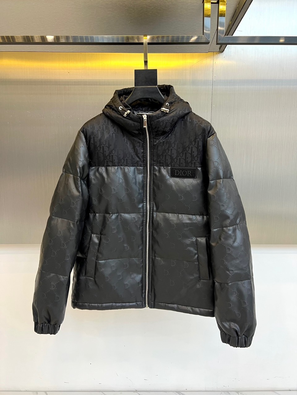 NO:712034,Dio Dior, the new down jacket for autumn and winter 2025, subverts the traditional modern aesthetics with its iconic black interpretation. This product innovatively adopts the design of completely different fabrics on the front and back. The front is crisp black quilted quilting, and the back is boldly spliced with matte leather to form a strong material.  Quality dialogue and deconstructive style. The detachable hood design is equipped with silver metal buckle tabs, which is both practical and exquisite. The surface of the clothing is faintly embossed with the same color CD letter dark pattern, and the left chest is embellished with a three-dimensional embroidery of the 'Dior' logo, showing a luxurious identity in a low-key manner.  It has a detachable wool blend lining inside, which can flexibly adapt to changing temperatures. The three-dimensional tailoring combined with a slight waistline can keep you warm while cleverly shaping your body, eliminating bulkiness. The overall style is both futuristic and pragmatic, which can not only resist the cold wave of the city, but also show off your extraordinary taste.  Fashion works with a pioneering attitude. Whether paired with simple trousers or layered, it can become a key item to shape your autumn and winter style. 48-56 (model weighs 173,143 pounds, upper body size 50),, dior, dior, down  jacket,hats,19860909Dio迪奥,2025秋冬新品羽绒服,以标志性黑色演绎颠覆传统的摩登美学.本品创新采用前后面料迥异的设计,正面为挺括的黑色绗缝夹棉,背面则大胆拼接哑光皮革,形成强烈的材质对话与解构主义风格.可拆卸连帽设计搭配银色金属扣袢,兼具实用性与精致细节.衣身表面隐约压印同色系CD字母暗纹,左胸点缀立体刺绣“Dior”徽标,低调中尽显奢华身份. 其内搭可拆卸羊毛混纺衬里,灵活适应多变气温.立体剪裁结合微收腰线,于保暖同时巧妙塑形,摒弃臃肿感.整体风格兼具未来感与实用主义,既能抵御都市寒潮,更是一件彰显非凡品味与先锋态度的时装作品.无论是搭配简约裤装,或是融入层次叠穿,皆能成为塑造秋冬型格的关键单品.48-56（模特173,143斤上身50码）,,dior,dior,down jacket,hats,,Men's clothing