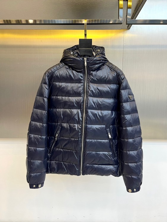 NO:712031,Prada, the new down jacket for autumn and winter 2025, adopts a neat short silhouette with a hooded design. The body is covered with smooth horizontal quilting lines, and the warm energy of 90% high-quality down is locked in through a three-dimensional filling process. The front is equipped with a smooth zipper opening and closing system, with practical diagonal pockets on both sides, and the cuffs are embellished with exquisite metal button details. The fabric is made of high-tech windproof material, and the surface presents a delicate glossy texture.  The style is a perfect fusion of Italian rationalism and practical philosophy. The short design optimizes body proportions, and horizontal quilting enhances visual hierarchy. The navy blue tone is both calm and fashionable. It can be paired with formal trousers to show business casual charm, or combined with jeans to create an urban daily look. From metal buttons to precise quilting, every detail is embodying  Reflecting Prada's ultimate pursuit of craftsmanship, this down jacket is not only a practical equipment to withstand the cold winter, but also interprets a sense of quietness and luxury with simple lines, making it an indispensable quality choice in the autumn and winter wardrobe. 48-56 (model is 173,143 pounds, upper body size 50),, prada, prada, jeans, down  jacket,hats,19860909Prad普拉达、2025秋冬新品羽绒服,款式采用利落短款廓形搭配连帽设计,衣身覆盖流畅的横向绗缝线条,通过立体填充工艺锁住90优质羽绒的温暖能量.前襟配备顺滑拉链开合系统,两侧设实用斜插口袋,袖口点缀精致金属纽扣细节.面料选用高科技防风材质,表面呈现细腻光泽质感. 风格上完美融合意式理性主义与实用哲学,短款设计优化身材比例,横向绗缝增强视觉层次感.海军蓝色调兼具沉稳与时尚气息,既能搭配正装长裤展现商务休闲魅力,亦可结合牛仔裤打造都市日常造型.从金属纽扣到精准绗缝,每处细节都体现普拉达对工艺的极致追求,这件羽绒服不仅是抵御寒冬的实用装备,更以简约线条诠释静谧高级感,成为秋冬衣橱中不可或缺的品质之选.48-56（模特173,143斤上身50码）,,prada,prada,jeans,down jacket,hats,,Men's clothing
